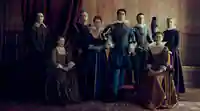 Mary Villiers (Julianne Moore) und ihr Sohn George (Nicholas Galitzine) posieren in aufwändiger Kleidung, umringt von anderen Adligen.