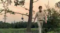 Abgebildet ist der Auftragskiller "Schakal" (Eddie Redmayne), wie er mit einer Waffe im Wald läuft.