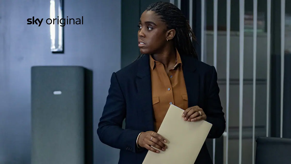 Die MI6-Agentin Bianca, gespielt von Lashana Lynch, hält die Geheimakte über den Schakal in den Händen.