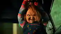 Abgebildet ist die dämonische Mörderpuppe "Chucky" wie sie versucht jemanden anzugreifen.
