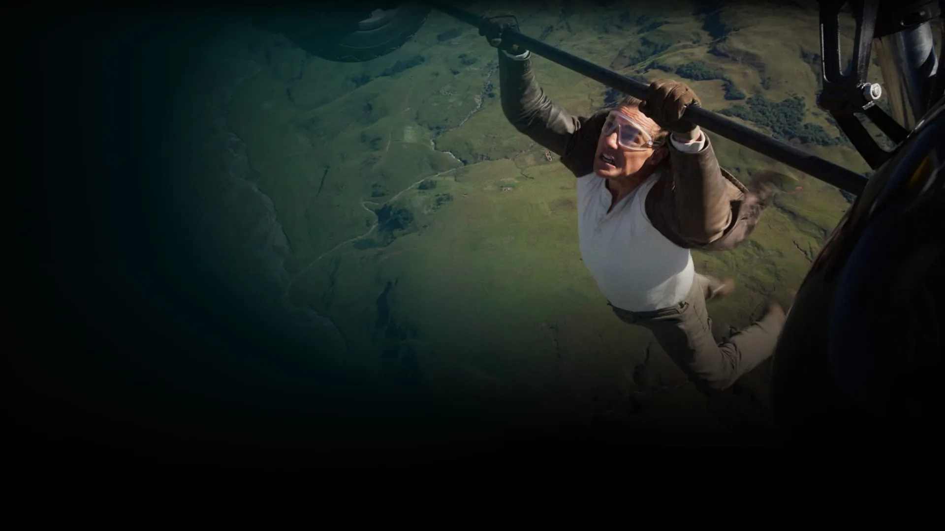 Tom Cruise hängt von einem Flugzeug.