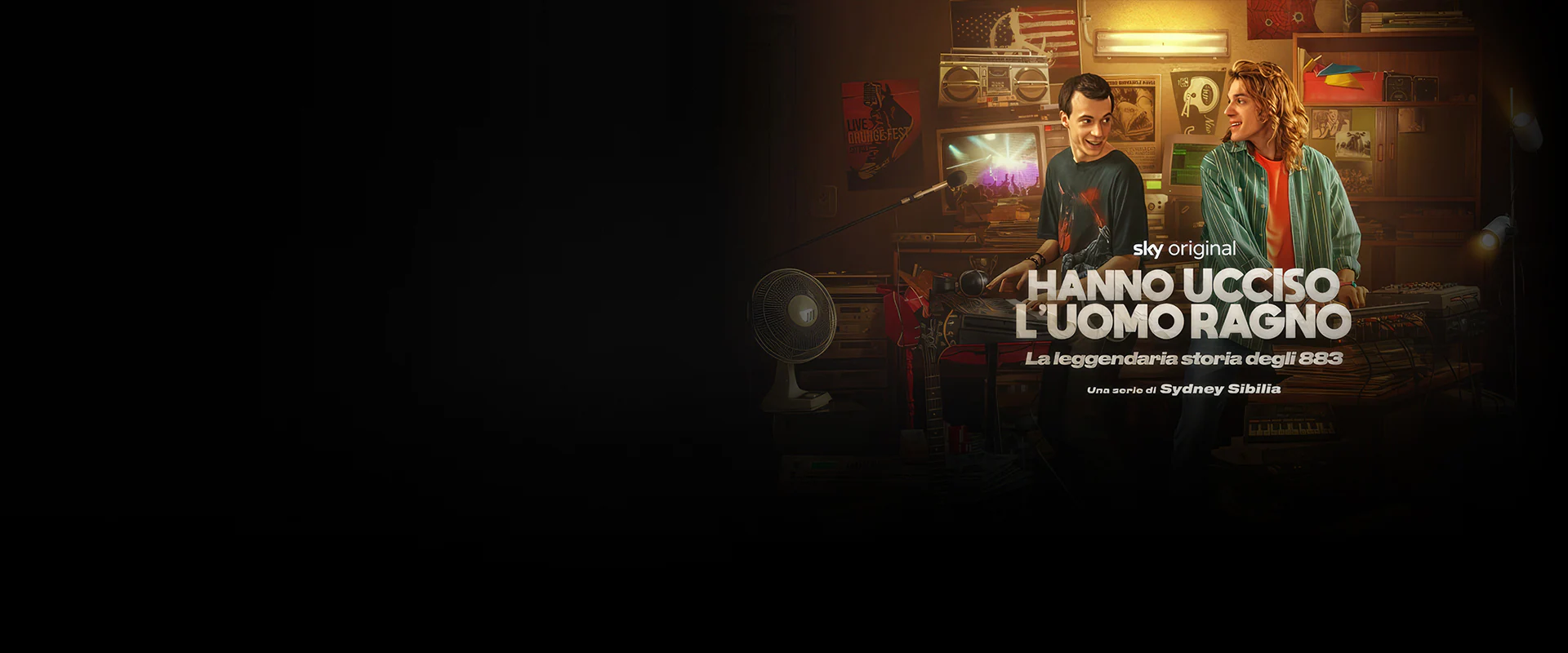 Immagine di sfondo Promozione Sky Original ‘Hanno Ucciso l’Uomo Ragno’ su NOW con Max Pezzali e Mauro Repetto in uno studio di registrazione anni ’90 circondati da mixer, computer e poster vintage
